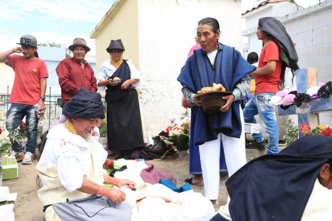 Tradición. En el cementerio de Cotacachi, cada familia se sienta en el suelo, alrededor de la tumba de su pariente, donde tienden un mantel y ponen la comida para compartir.