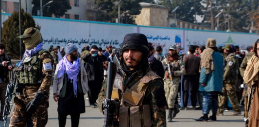 Milicianos armados custodian la manifestación de cientos de afganos que exigieron frente a la vacía exembajada de EE.UU. la entrega de recursos.