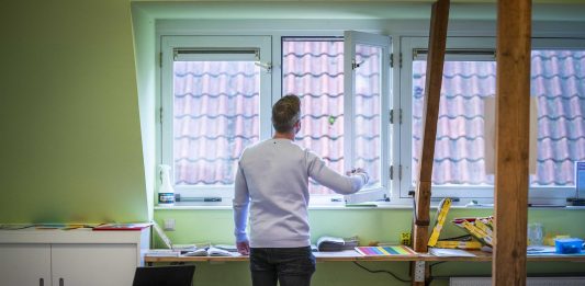 Un profesor de Países Bajos abre las ventanas del aula donde el lunes reiniciará clases.