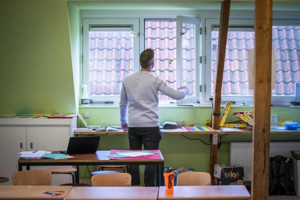 Un profesor de Países Bajos abre las ventanas del aula donde el lunes reiniciará clases.