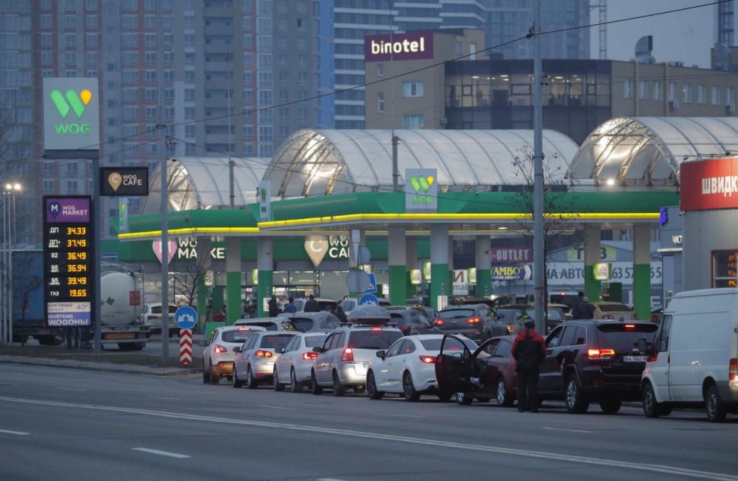 Conductores esperan para cargar gasolina que les permita huir de la capital de Ucrania.