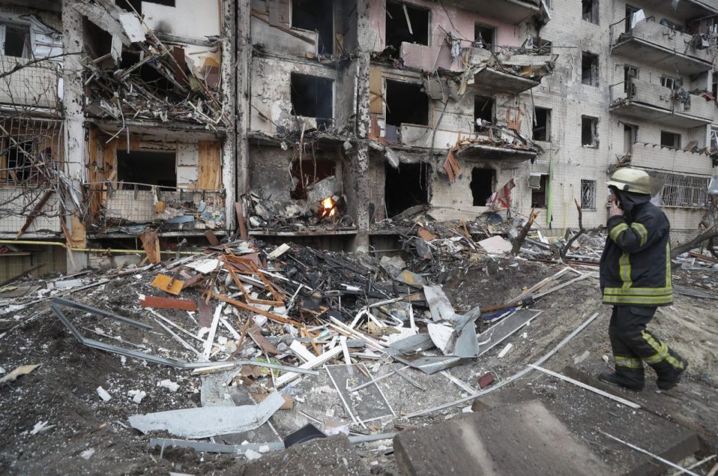 Un miembro de los servicios de emergencia evalúa los daños ocasionados por los bombardeos rusos sobre una zona residencial de Kiev.