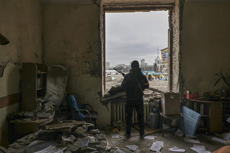 Un ucraniano monta guardia en lo que queda de un edificio en una zona bombardeada por fuerzas rusas.