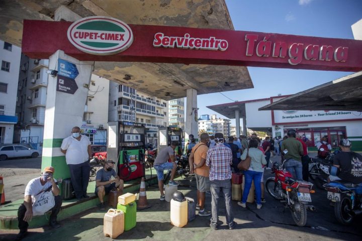 Personas esperan para comprar combustible en una estación luego que las autoridades regularán la venta a particulares.