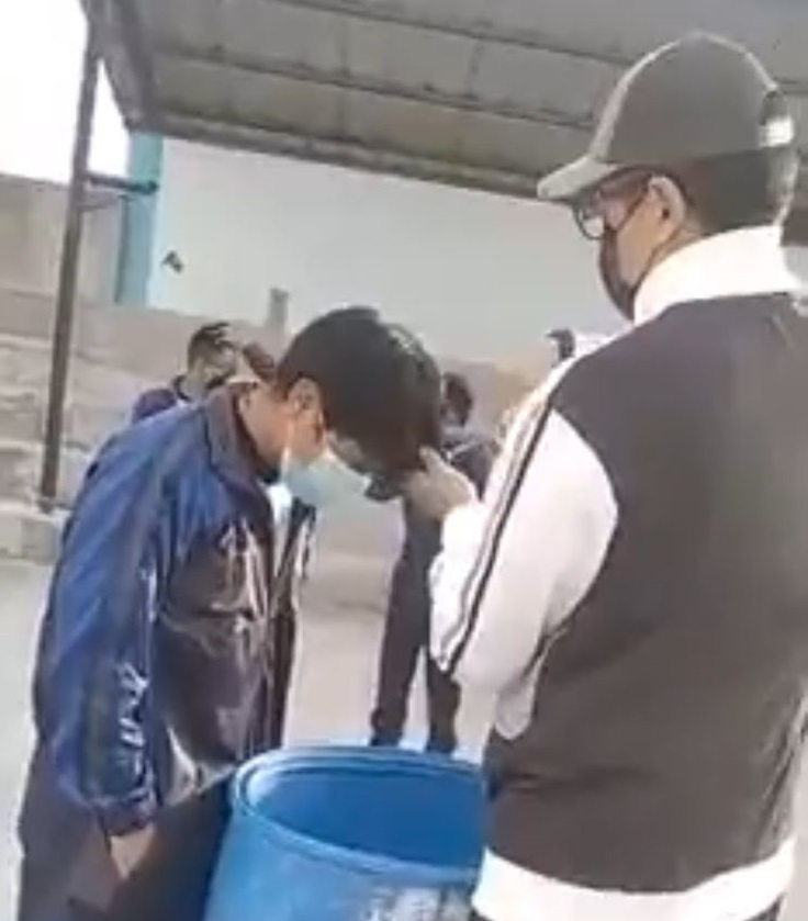 Captura de pantalla del video en el que se ve al maestro cortar el cabello a sus alumnos.