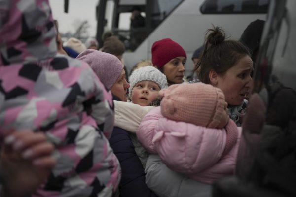 Adultos y niños ucranianos esperan para abandonar el país en la estación de autobuses de Leópolis.