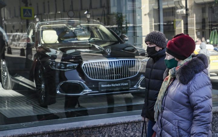 REALIDAD. Los rusos caminan frente a una exhibición de una sala de exhibición de Mercedes-Benz en Moscú.