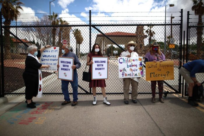 Personas sostienen pancartas a favor de los niños migrantes, en la entrada de la base militar de Fort Bliss (Texas).