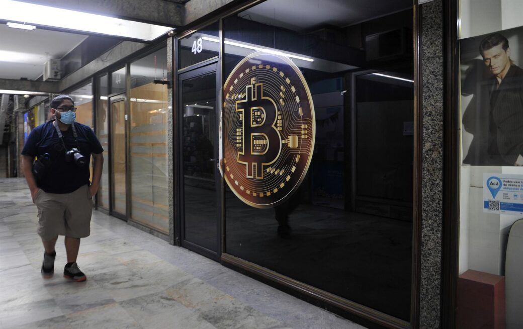 Un hombre camina frente a una tienda de criptomonedas en la capital argentina.