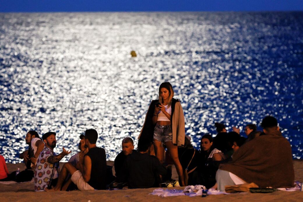 Personas festejan en una playa de Puerto Rico en una noche calurosa.