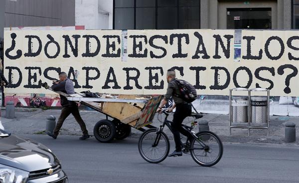 INCERTIDUMBRE. En un letrero pintado en una calle de Bogotá se exige respuesta por los desaparecidos en Colombia. EFE