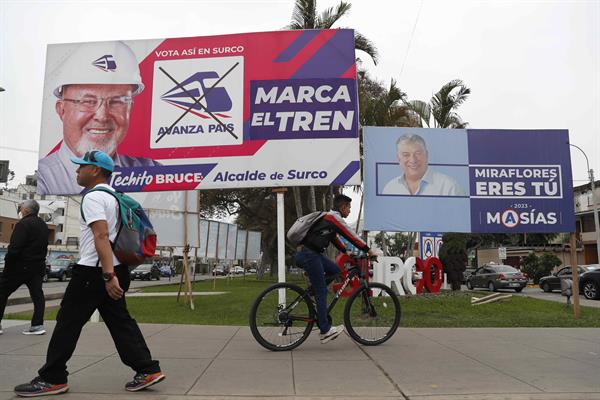 INDIFERENCIA. Personas pasan frente a propaganda electoral en una calle, el 19 de septiembre de 2022, en Lima. EFE
