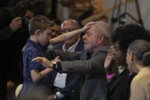 Ceremonia. Luiz Inácio Lula da Silva mientras recibe una oración de un niño de 9 años de edad.