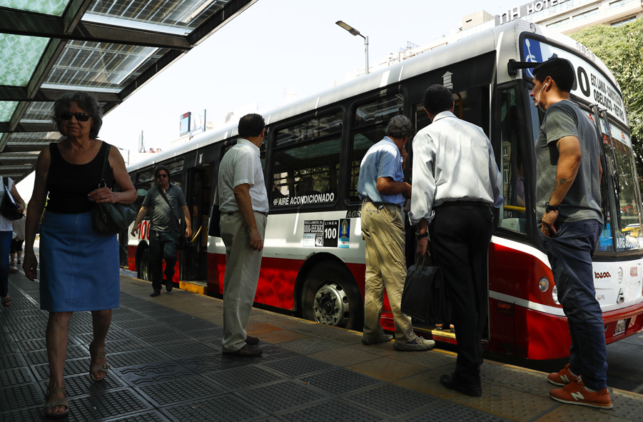 Transporte. Usuarios esperan en una parada de autobuses públicos de Buenos Aires. EFE