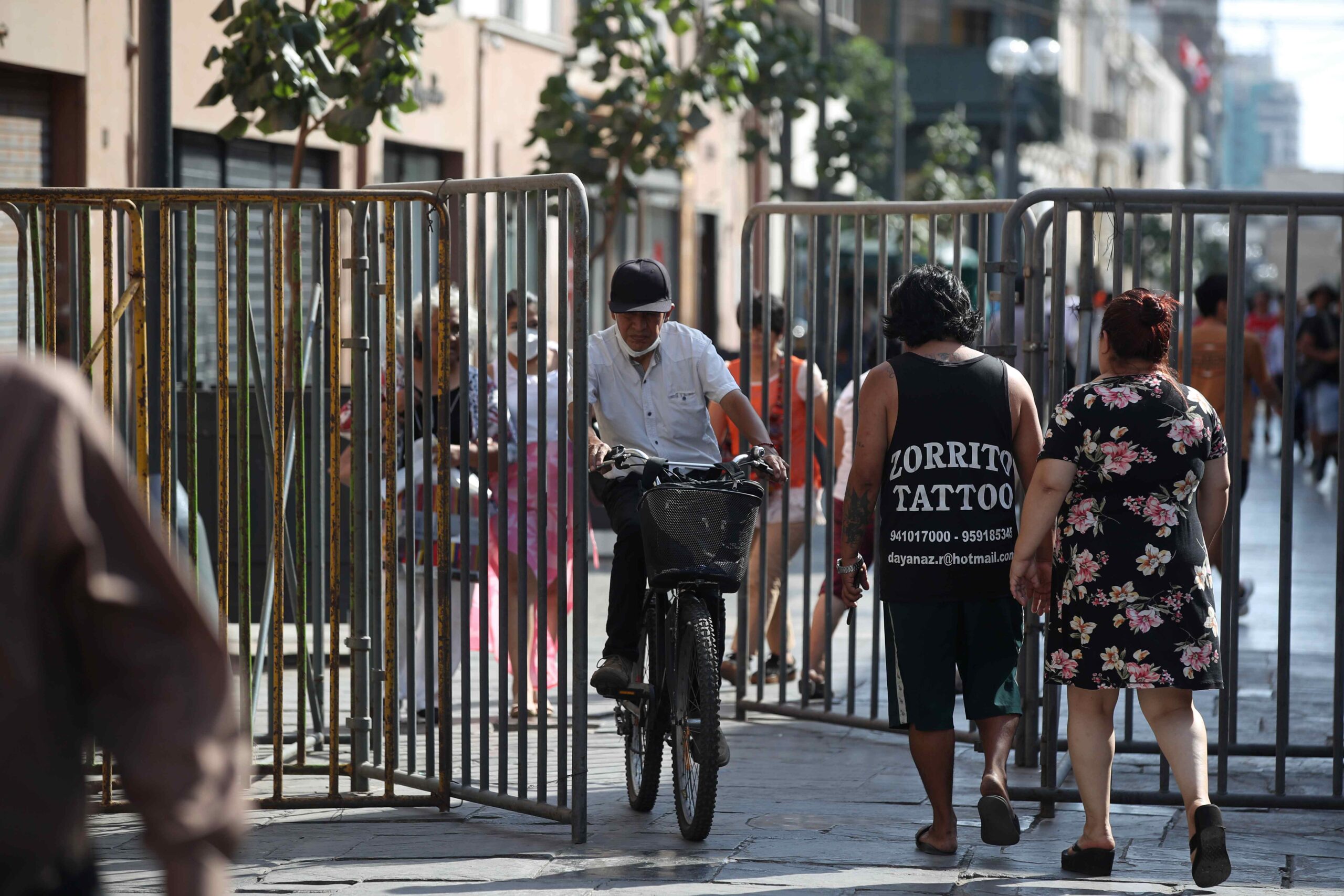 Varias personas cruzan una valla de seguridad instalada durante las protestas, el 26 de enero de 2023, en Lima (Perú).
