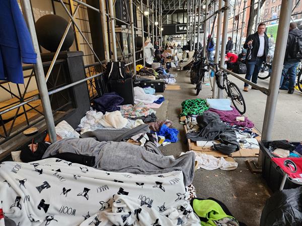 Personas migrantes venezolanas desalojadas de un hotel permanecen en la calle de Nueva York, en una fotografía de archivo.EFE