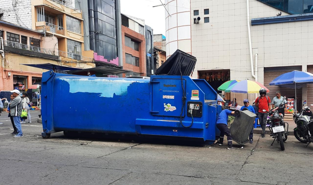 Personal del limpieza del mercado Modelo luego de arrojar los desechos, golpean los tachos en la calles para que salgan todos los desperdicios y la basura queda en la calzada. (Foto tomada el jueves 19 de mayo de 2023)