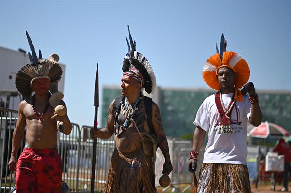 PROTESTA. Indígenas caminan frente a un campamento instalado cerca de la Explanada dos Ministerios hoy en Brasília (Brasil).