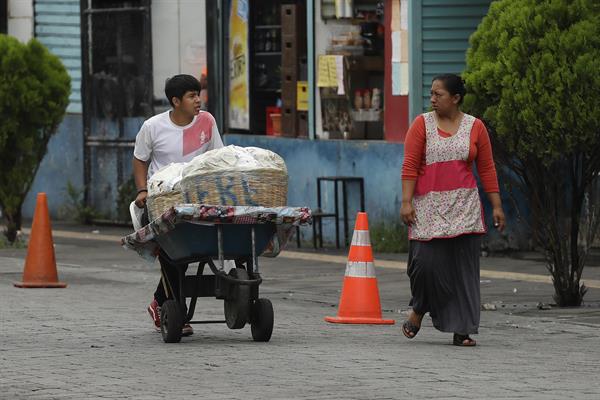 Un menor traslada mercadería en una carretilla, el 7 de junio de 2023 en San Salvador (El Salvador).