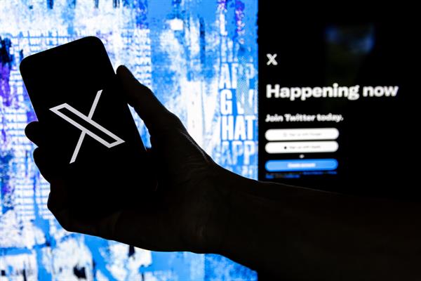 Tendencia. Un usuario sostiene un teléfono móvil que muestra el logotipo de la página 'X'. EFE