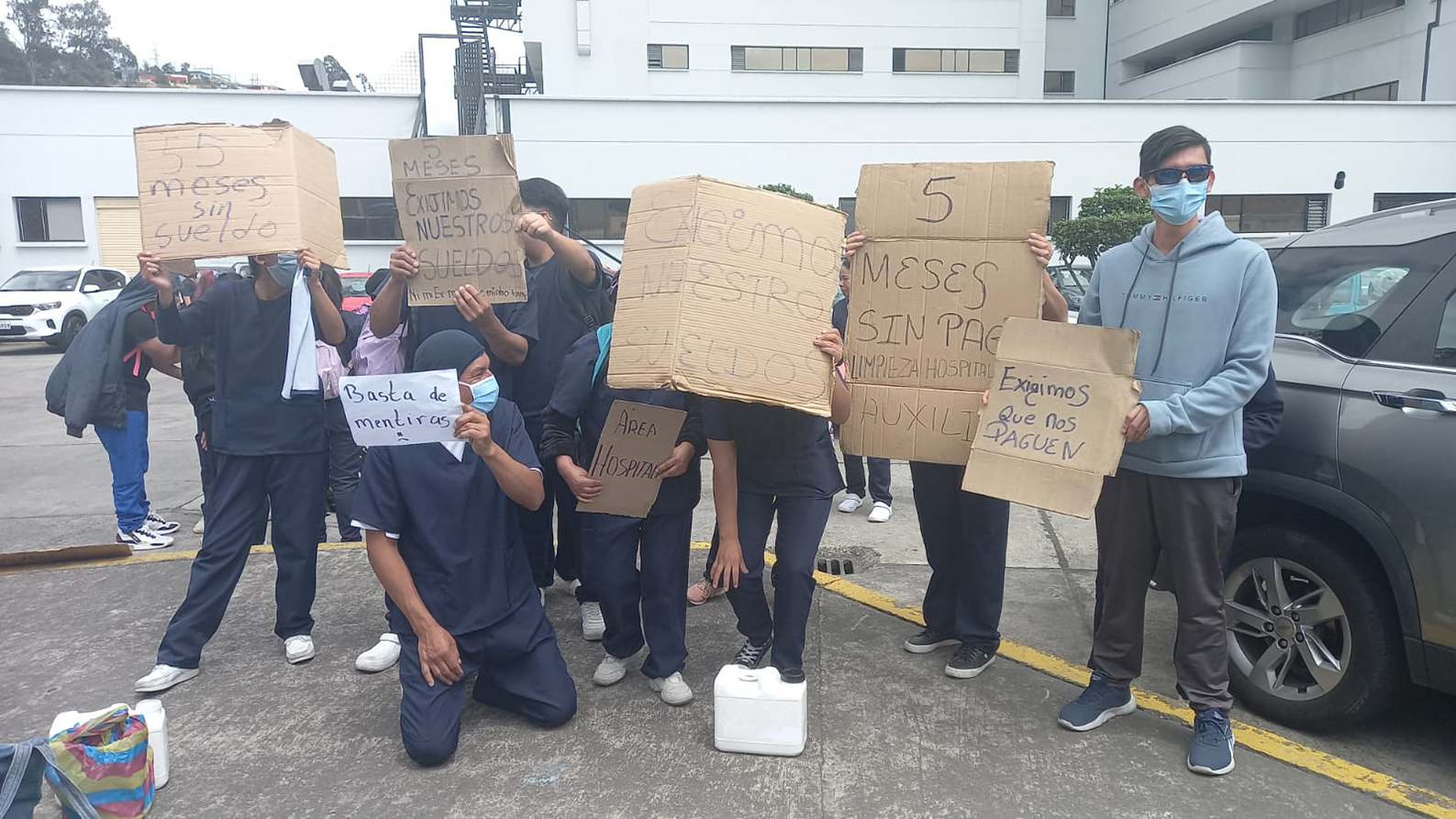 Los trabajadores de limpieza protestaron en el garaje del Hospital del IESS Ambato con varias pancartas.