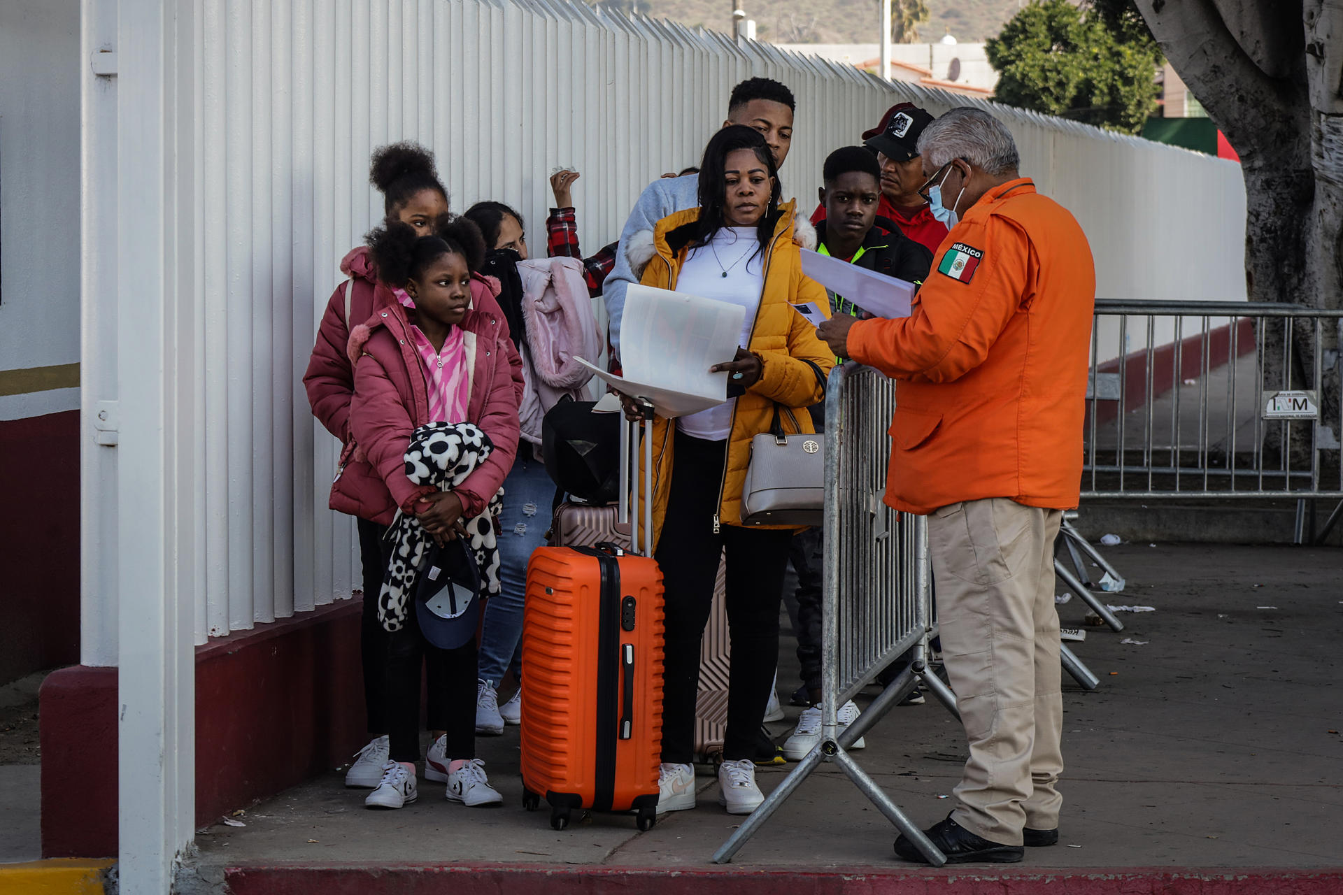 RALIDAD. Migrantes hacen fila para solicitar un proceso de asilo en Estados Unidos, el 25 de enero de 2024 en el paso fronterizo del Chaparral en Baja California (México). (EFE/Joebeth Terríquez)