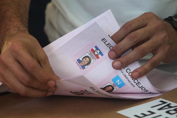 ESCRUTINIO. Un miembro de junta receptora de votos cuenta papeletas en El Salvador. EFE