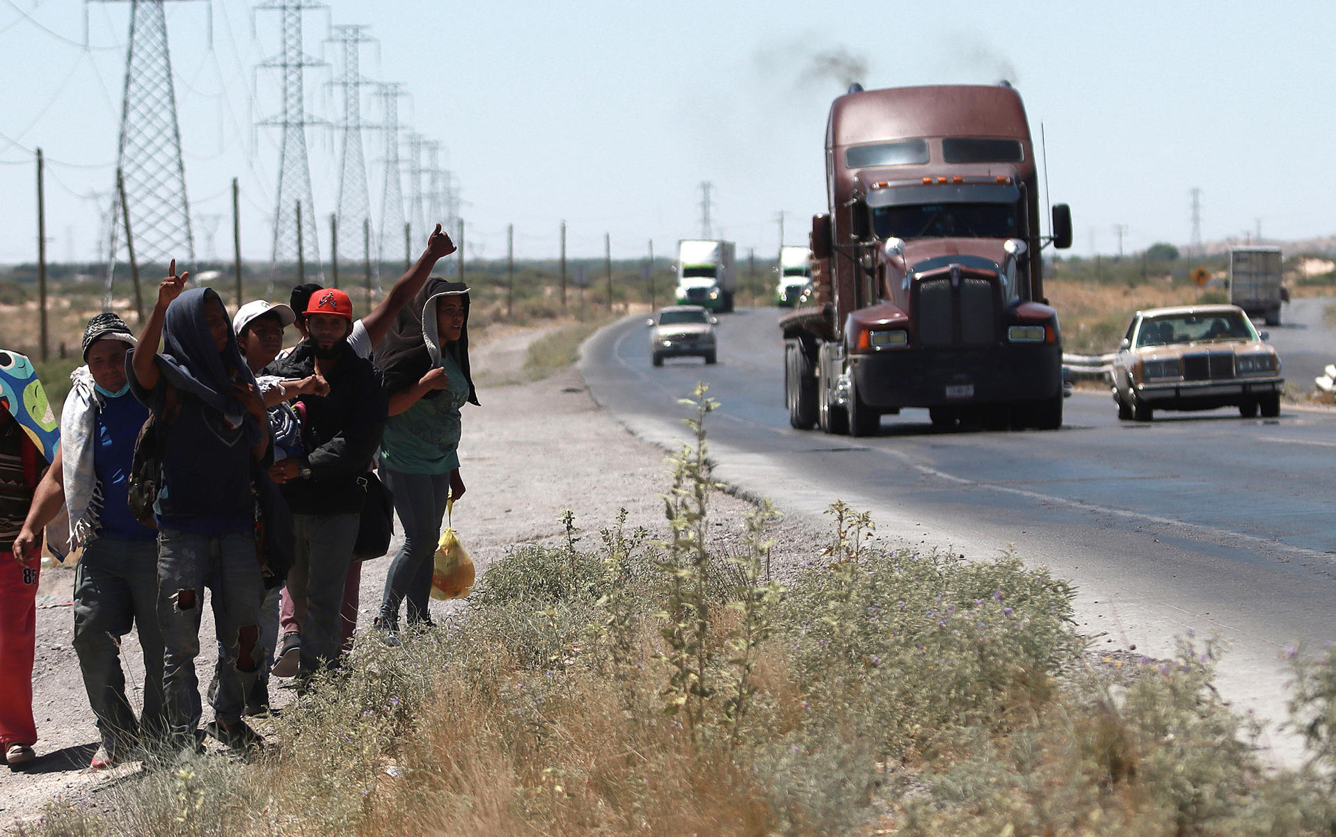 TRAVESÍA. Un grupo de migrantes camina a un costado de la carretera rumbo a la frontera con Estados Unidos, en la ciudad de Chihuahua (México). EFE
