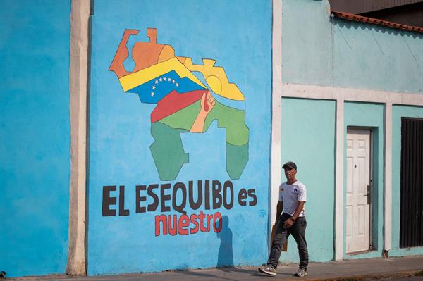 Foto de archivo de un transeúnte frente a un mural con el mapa de Venezuela que dice "El Esequibo es nuestro", en Caracas (Venezuela). EFE/