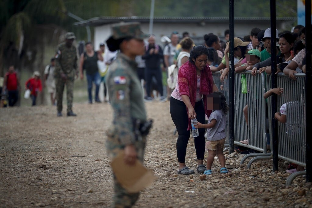 Una migrante con una niña esperan en una estación de recepción migratoria luego de cruzar la selva del Darién con rumbo a los Estados Unidos, en Lajas Blancas (Panamá).